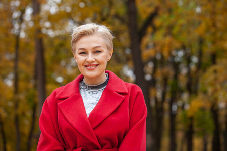 Autumn portrait of a middle aged woman in a red coatの写真素材