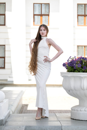 Full-length portrait of a young beautiful woman in a long white dressの写真素材