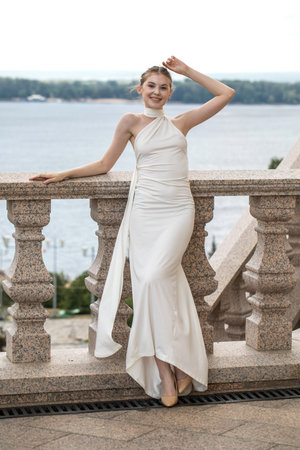 Full-length portrait of a young beautiful woman in a long white dressの写真素材
