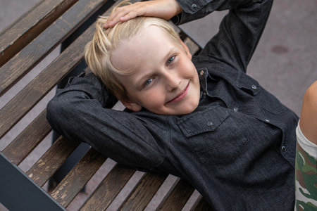 Portrait of a blond teenage boy in the yard on the streetの写真素材