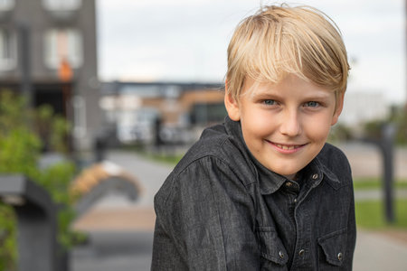 Portrait of a blond teenage boy in the yard on the streetの写真素材