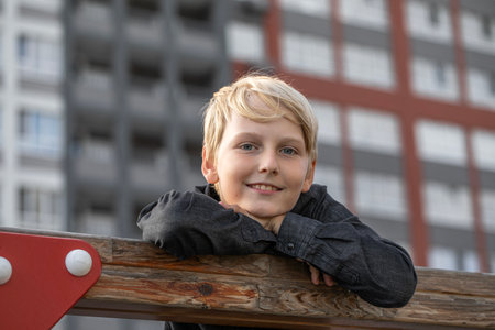 Portrait of a blond teenage boy in the yard on the streetの写真素材