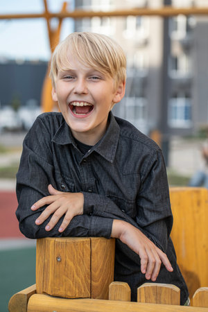 Portrait of a blond teenage boy in the yard on the streetの写真素材