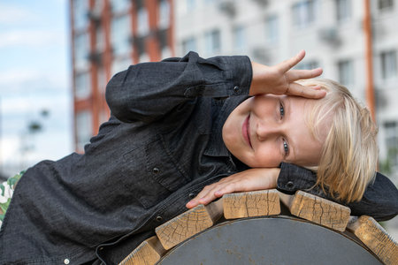 Portrait of a blond teenage boy in the yard on the streetの写真素材