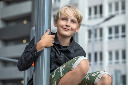 Portrait of a blond teenage boy in the yard on the streetの写真素材