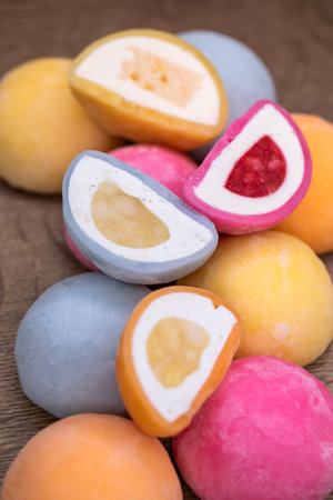 Mochi - sweet Japanese dessert. Whole and pieces of dessert on a wooden boardの写真素材