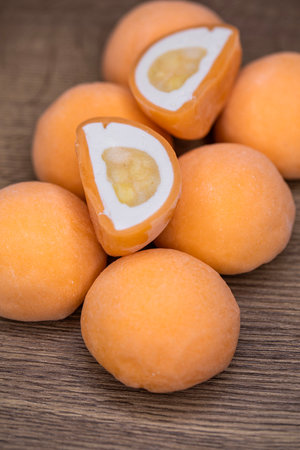 Mochi - sweet Japanese dessert. Whole and pieces of dessert on a wooden boardの写真素材