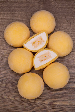 Mochi - sweet Japanese dessert. Whole and pieces of dessert on a wooden boardの写真素材