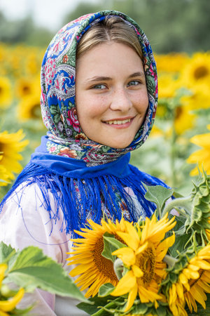 Slavyanka. Portrait of a young beautiful girl in a field of sunflowersの写真素材