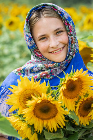 Slavyanka. Portrait of a young beautiful girl in a field of sunflowers