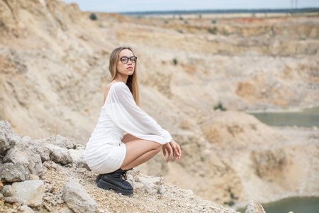 Full body portrait of a young blonde woman in a white short dress with long sleevesの写真素材