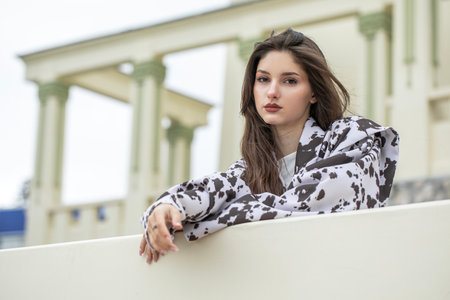 Portrait of a young beautiful brunette woman. Stylish jacket - black and white spotted.