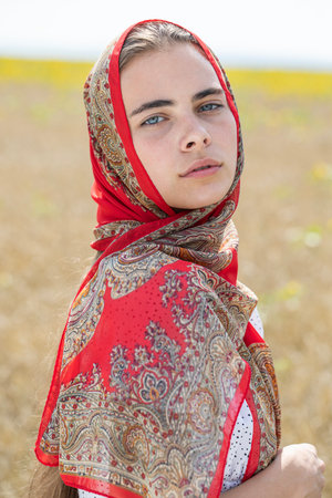 Portrait of a young beautiful girl with a scarf on her head
