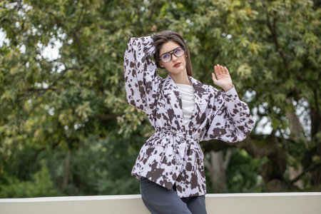 Portrait of a young beautiful brunette woman. Stylish jacket - black and white spotted.