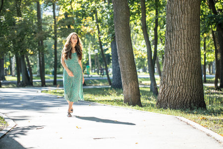 Fashion portrait of a young beautiful woman in a turquoise dressの写真素材