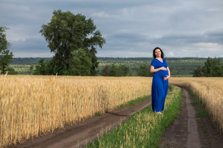Full length portrait of a pregnant woman in natureの写真素材