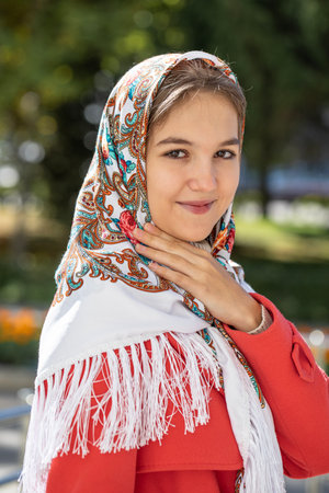 Portrait of a young beautiful girl with a scarf on her headの写真素材