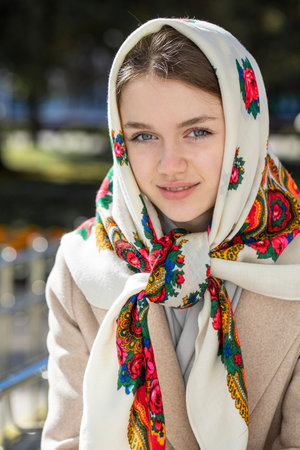 Portrait of a young beautiful girl with a scarf on her headの写真素材