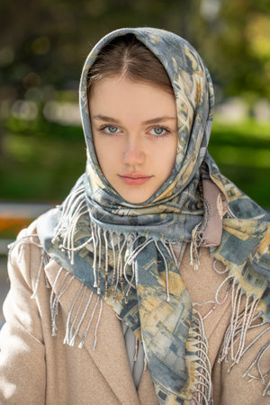 Portrait of a young beautiful girl with a scarf on her headの写真素材
