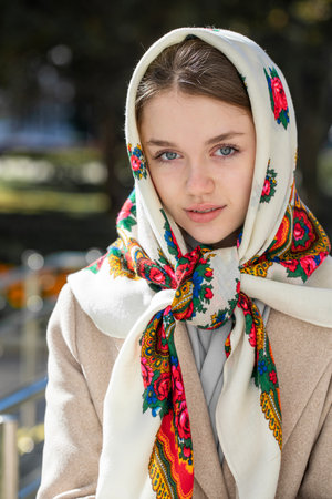 Portrait of a young beautiful girl with a scarf on her headの写真素材