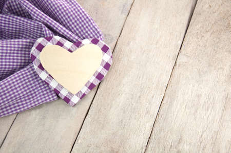 invitation decorated with violet and white heart on a rustic wooden tableの写真素材