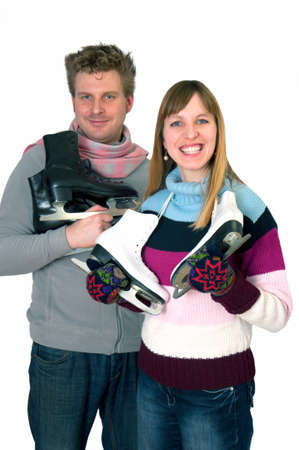 Young woman and man holding ice skates preparing for winter sportsの写真素材