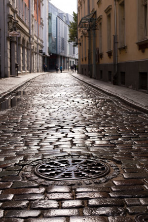 Paving stone and sunlight. Old street floor pavement background. Street tiles in europe and people walking.の写真素材