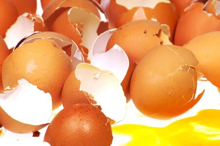 egg yolk running in front of broken shellsの写真素材