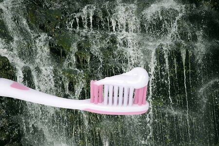 toothbrush ready to go with toothpaste applied in front of beutifual pure streamの写真素材