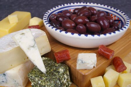 cheese antipasto varieties on board with kalamata olivesの写真素材