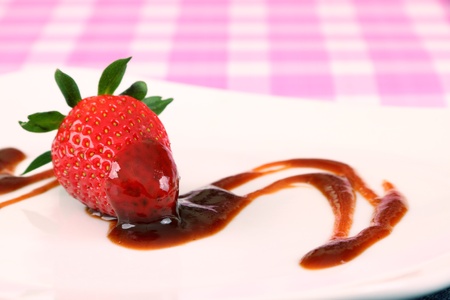 Single strawberry with brown sryup either chocolate vinegar or sauceの写真素材