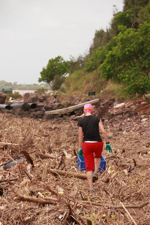 BRISBANE, AUSTRALIA - JAN 15 : Flood  and storm debris on Brisbane beach with community volunteers cleaning January 15, 2011 in Brisbane, Australia のeditorial素材