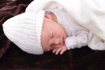 newborn infant baby on fur baby rug having nap timeの写真素材
