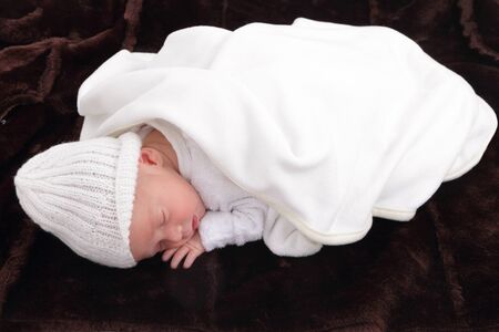 newborn infant baby on fur baby rug having nap timeの写真素材