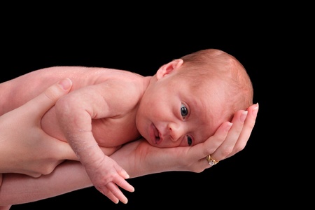 small premature baby girl being held for an isolated portraitの写真素材