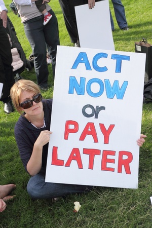 BRISBANE, AUSTRALIA - JUNE 6 : Woman with act now or pay later anti polution sign at say Yes to carbon tax World Enviroment Day protest 6, 2011 in Brisbane, Australia のeditorial素材