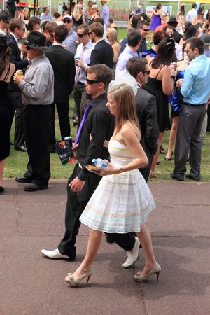 BRISBANE, AUSTRALIA  NOV 01 : Young couple walking back to drinking spot amoungst crowds at Eagle Farm Racourse as part of Melbourne Cup race day across Australia November 01, 2011 in Brisbane, Australia のeditorial素材