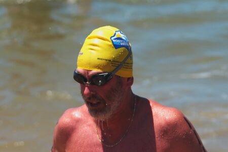BRISBANE, AUSTRALIA  NOV 27 :Older man finishes the 5km open water swim called Great Australian Swim Series race November 27, 2011 in Brisbane, Australia のeditorial素材