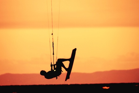 kite surfer boarding shilouette against brisbane bayside beach skyの写真素材