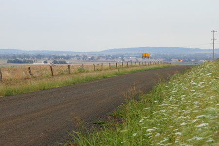 gravel no lines bush road hemlock on side of padocks queensland australiaの写真素材