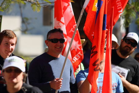 BRISBANE, AUSTRALIA - JULY 06 : Unidentified protesters with NUW union flags at Bust The Budget anti liberal governement Rally July 06, 2014 in Brisbane, Australiaのeditorial素材