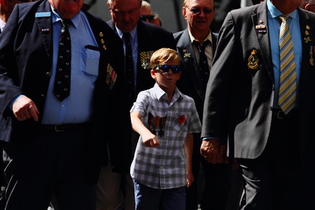 BRISBANE, AUSTRALIA - APRIL 25 : Proud grandson wears relatives medals whilst marching during Anzac...