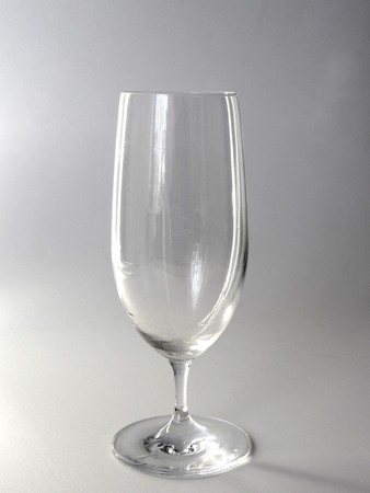 A single transparent wine glass on a white background in a vertical photo.の写真素材