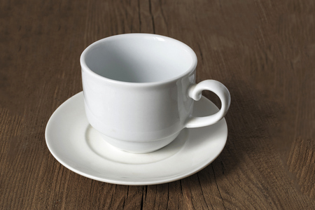 Ordinary empty white coffee cup on a wooden old table.の写真素材