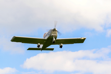 A small plane performs a flight in the background is a blue sky.の写真素材