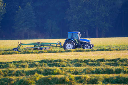 Mechanization of agriculture. Modern agricultural equipment is used to harvest hay.の写真素材