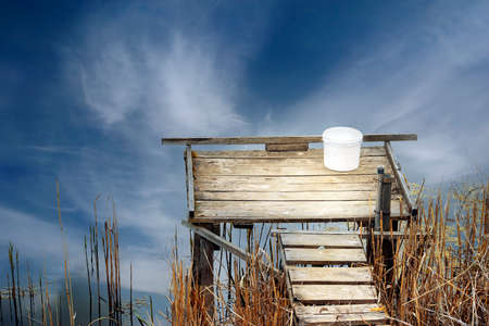 Beautiful view of the fishing platform on the lake picture of the reflection of the blue sky on the water.の写真素材