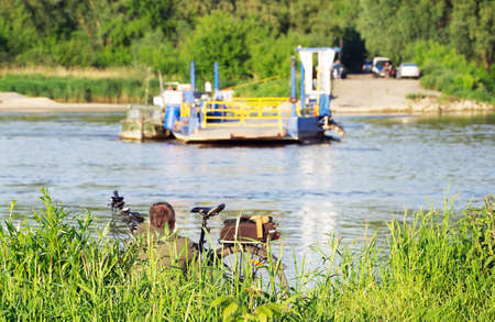 A man with a bicycle is waiting for the crossing to the other side of the river.の写真素材