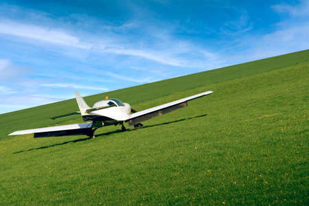 A small plane takes off from a grassy airport. The tilted horizon adds dynamics to the photo.