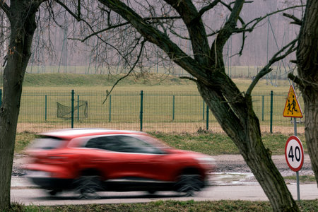 A red car is traveling at high speed on a road with a speed limitの写真素材